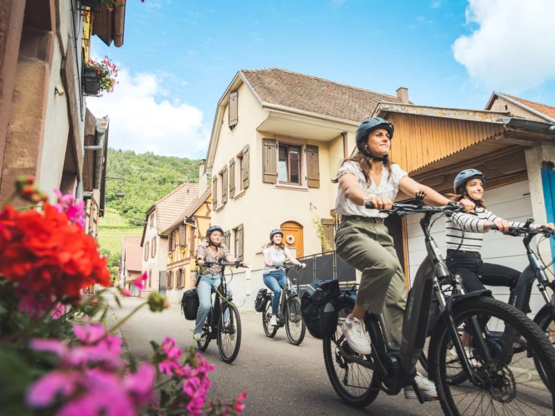 Groupe de cyclistes dans une jolie ruelle de Châtenois