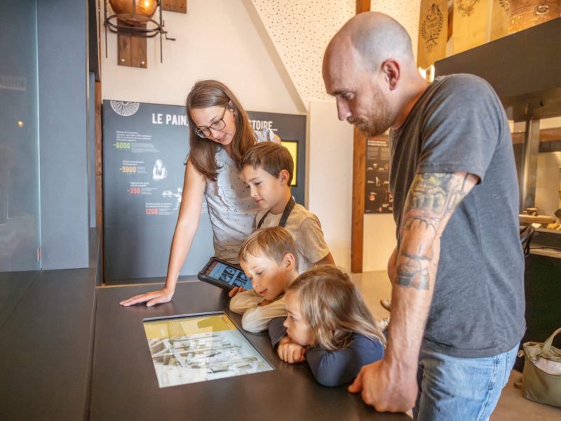 Famille qui découvre les dispositifs numériques de la Maison du Pain de Sélestat